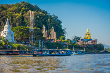 Outdoor view of a group of tourists in a tourist boat visiting the golden budha located at golden triangle Laos