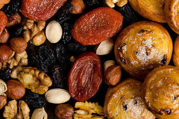 Nuts, dried fruits, pistachios and homemade cookies are scattered from the bag on the table