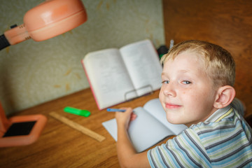 Fototapeta na wymiar Happy boy with smile face and looking at camera doing homework