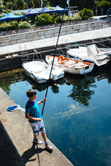 Obraz premium Child fishing at the harbor