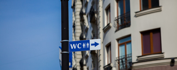 Fototapeta na wymiar WC sign in old town. Toilet sign in European city