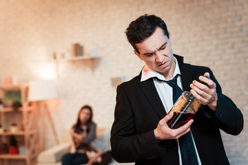Drunk man in suit drinks alcohol at home. Family alcoholic. Drinking alcohol.
