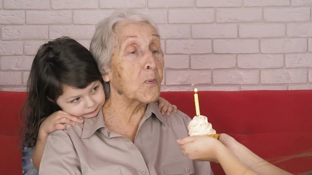 Grandmother's birthday. Children with grandmother. Granddaughter congratulate grandmother on his birthday.
