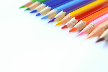 Colored pencils on white background with space for text.