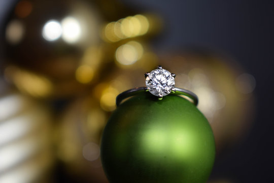 Close Up Of A Diamond Engagement Ring Resting On A Christmas Ornament