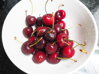 Delicious red cherries in a white cup.