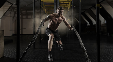 Fototapeta na wymiar Man working out with battle ropes