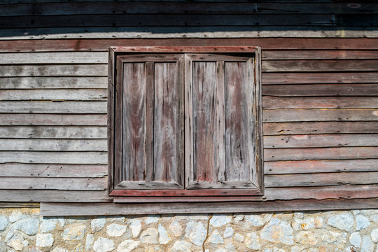 Background of the old wooden window with old stone and wooden wall in Thai house styles 