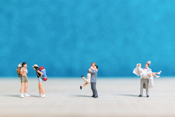 Naklejka premium Miniature people : Bride and groom on blue background.
