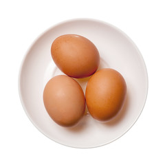 Three brown eggs on plate