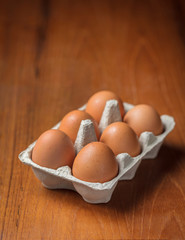 Brown eggs in cardboard on table