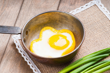 Bell pepper egg rings on a cooking pan and green onion 