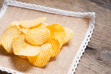 Crispy potato chips on a tablecloth 