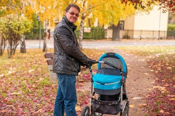 A walk in the Park with a stroller. Dad with a stroller.