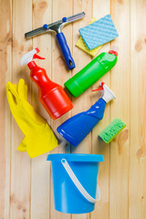 Cleaning concept - cleaning supplies on wood background