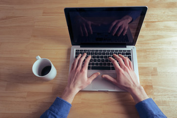 office hand on laptop and cup of coffee 