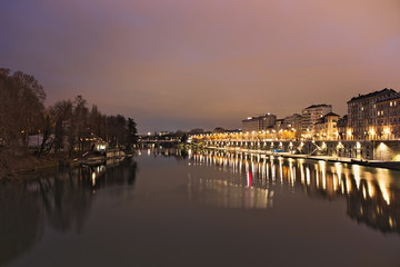 Fototapeta premium Po river flowing in Torino city, Italy, Murazzi docks, night view