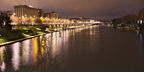 Fototapeta na wymiar Po river flowing in Torino city, Italy, Murazzi docks, night view