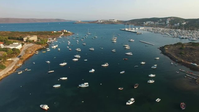 Picturesque mediterranean seascape of Aegean sea bay with yachts, sailing, motor and fishing boats spread all over water. Olympic marina on the background. Lavrio town, Attica, Greece. Aerial.