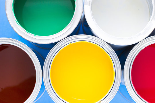 House renovation, paint cans on blue background top view