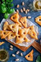 Parmesan cookies shaped like pieces of cheese on a wooden board, selective focus, top view