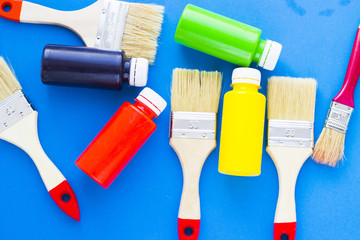 House renovation, paint cans and paintbrushes on blue background top view