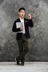 Full length portrait of an excited young asian man