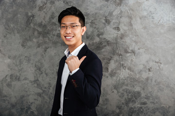 Portrait of a smiling young asian man dressed in suit