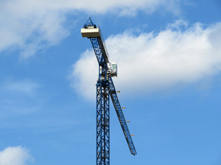 Construction crane against the cloudy blue sky