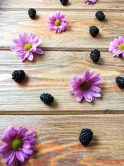 BlackBerry on wooden background with flowers