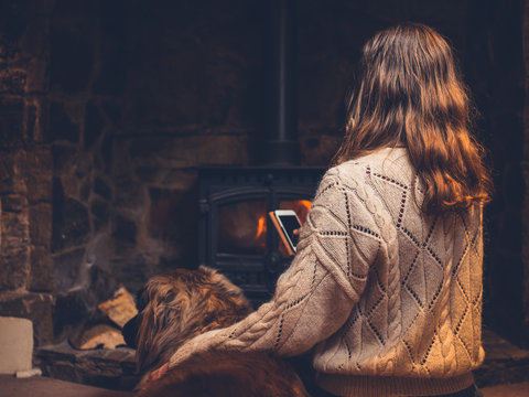 Young woman with dog by the fire