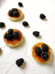 BlackBerry and pancake on aged wooden background with flowers and coffee