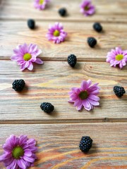 BlackBerry on wooden background with flowers