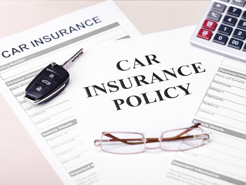 Car insurance policy. Document, key, glasses on table. Business and insurance background concept.