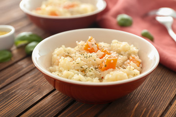Dish with delicious pumpkin risotto on wooden table
