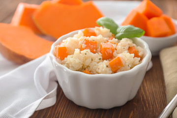 Dish with delicious pumpkin risotto on table