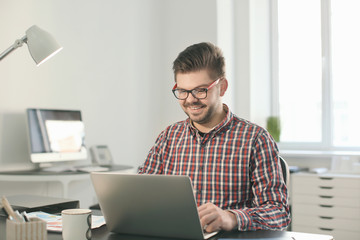 Young man with laptop working in office