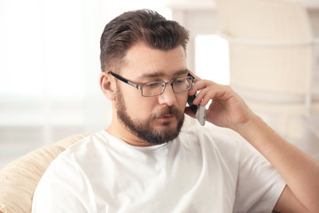 Young man talking on phone while working at home