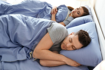 Fototapeta premium Young couple sleeping in bed at home. Family bedtime