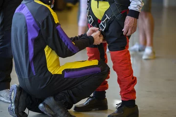 Photo sur Plexiglas Sports aériens Skydiver Instructor Helps Apprentice to Tie Security Belt on His Parachutist Suit