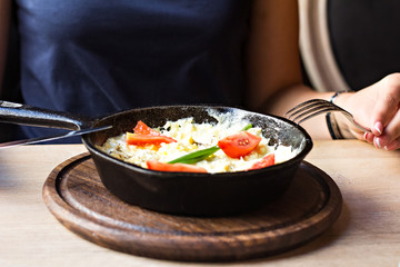 Omelette with tomatoes in a frying pan.