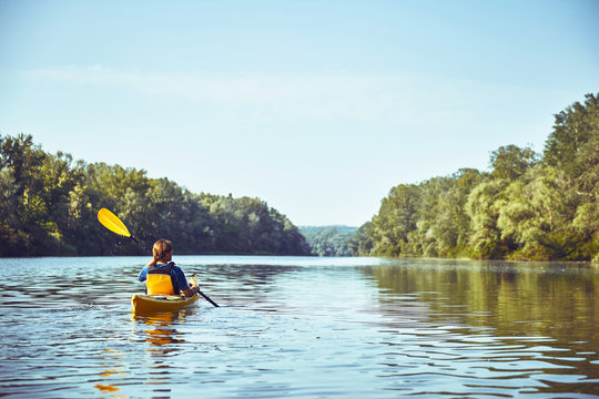 A canoe trip along the river along the forest in summer.
