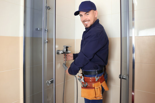 Plumber working in shower stall
