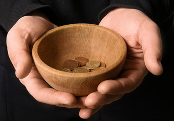 Poor man with bowl and coins, closeup