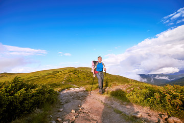 Hiking in the mountains in the summer with a backpack.