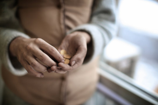 Poor woman holding coins, closeup