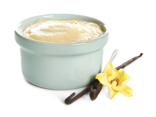 Tasty vanilla pudding in ramekin and sticks with flower on white background