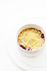 Cherry crumble in a white form on a white background. Food concept