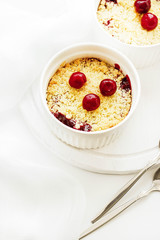 Cherry crumble in a white form on a white background. Food concept