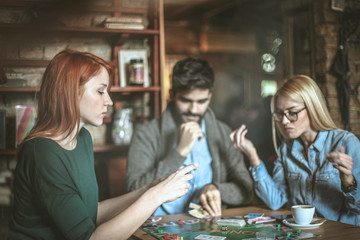 Fototapeta premium Friends at cafe playing leisure game.